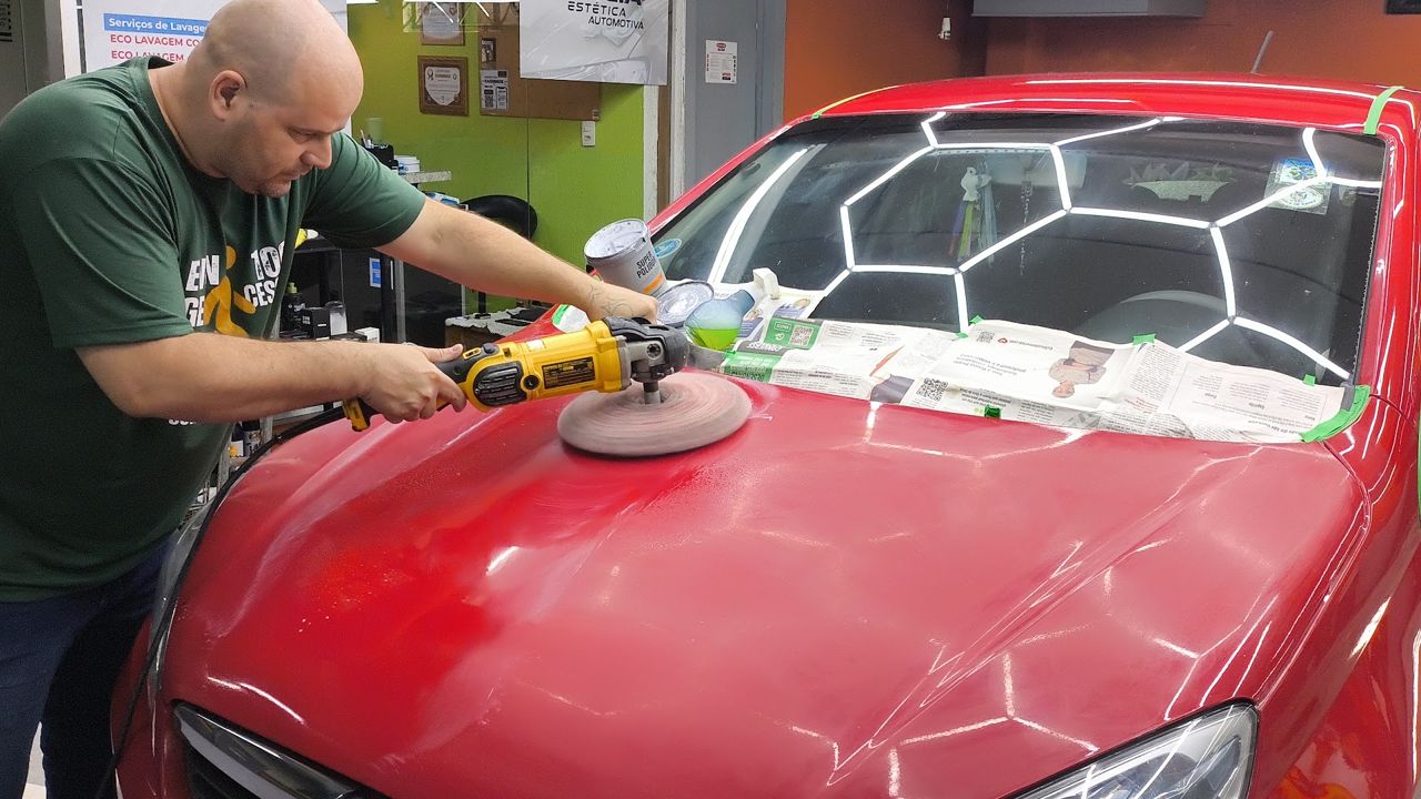 Profissional da Garcia polindo o capô de um carro vermelho
