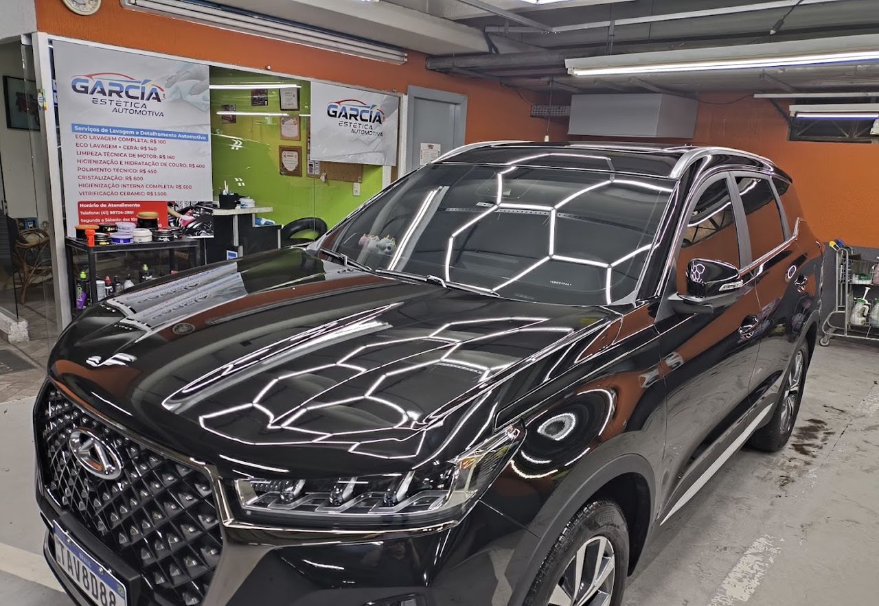 SUV Caoa Chery preto com o teto de LED hexagonal refletido no capô polido